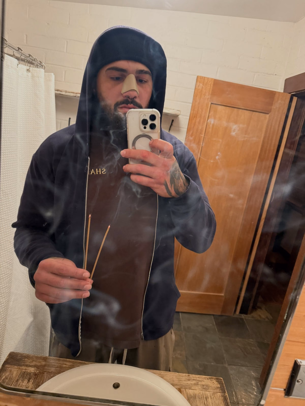 Hood up, incense burning, alone.